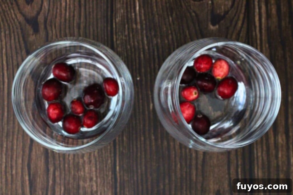 Step 1: Place a handful of fresh or frozen cranberries at the bottom of a glass and add water.
