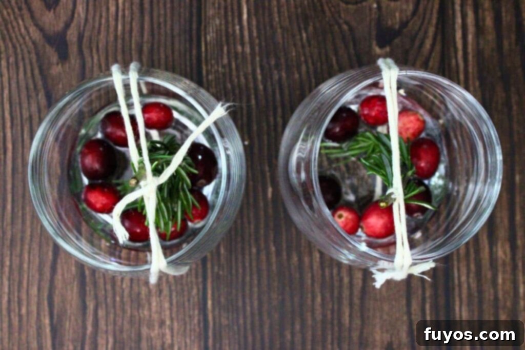 Step 2: Carefully position a rosemary sprig upright in the center of the glass, creating a miniature tree.