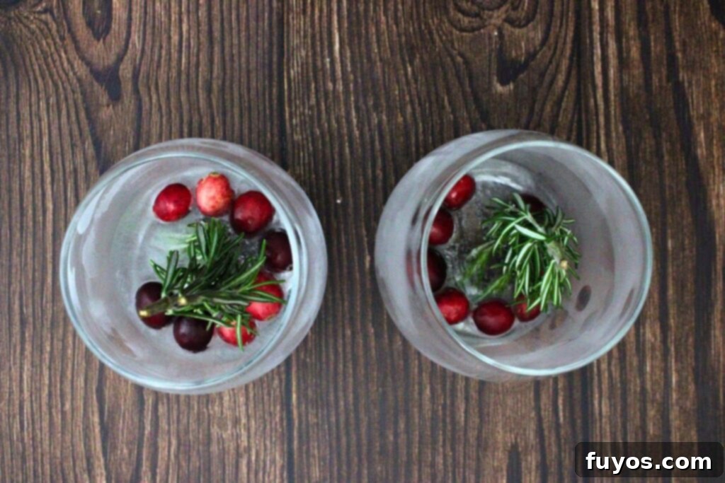 Step 3: Glasses with cranberries and rosemary are placed in the freezer to set the festive ice block.