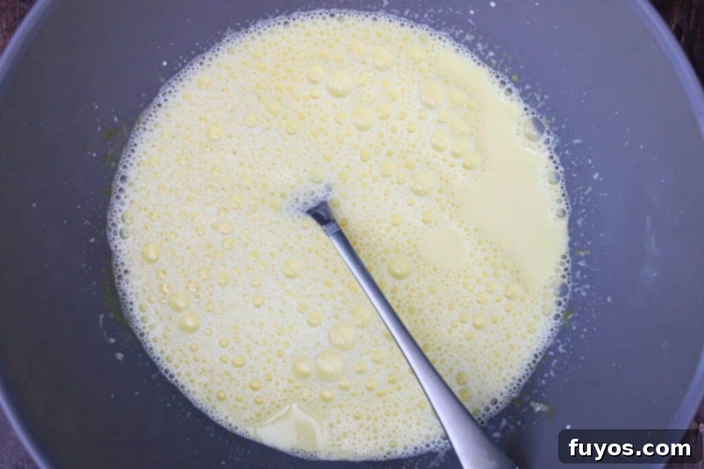 slowly whisk hot cream into egg mixture
