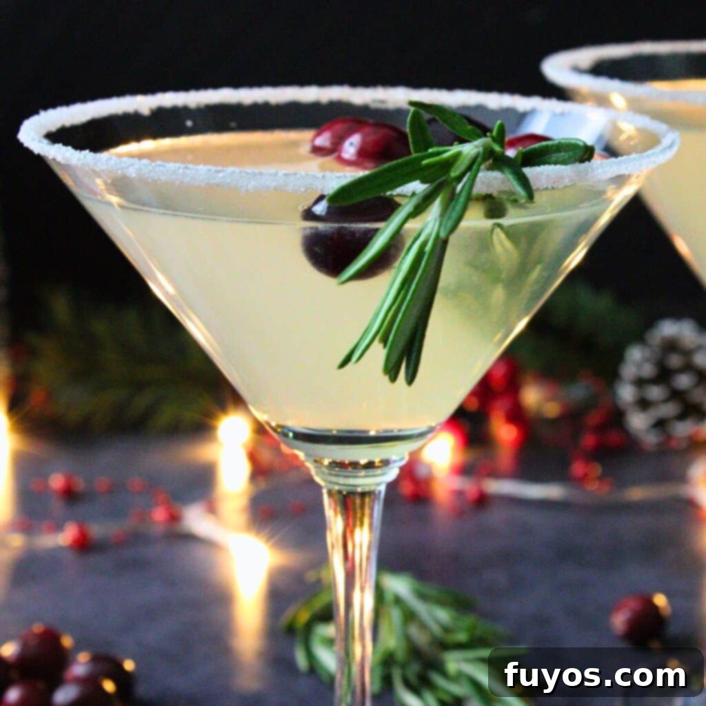 A festive Christmas Lemon Drop Cosmo, garnished with rosemary and cranberries, against a blurred holiday backdrop.