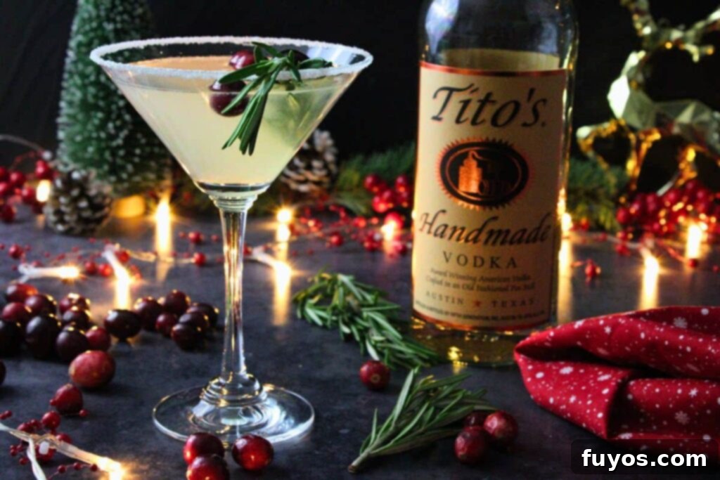 Close-up of a Christmas Lemon Drop Cosmo in a martini glass next to a vodka bottle in a classy holiday setting.
