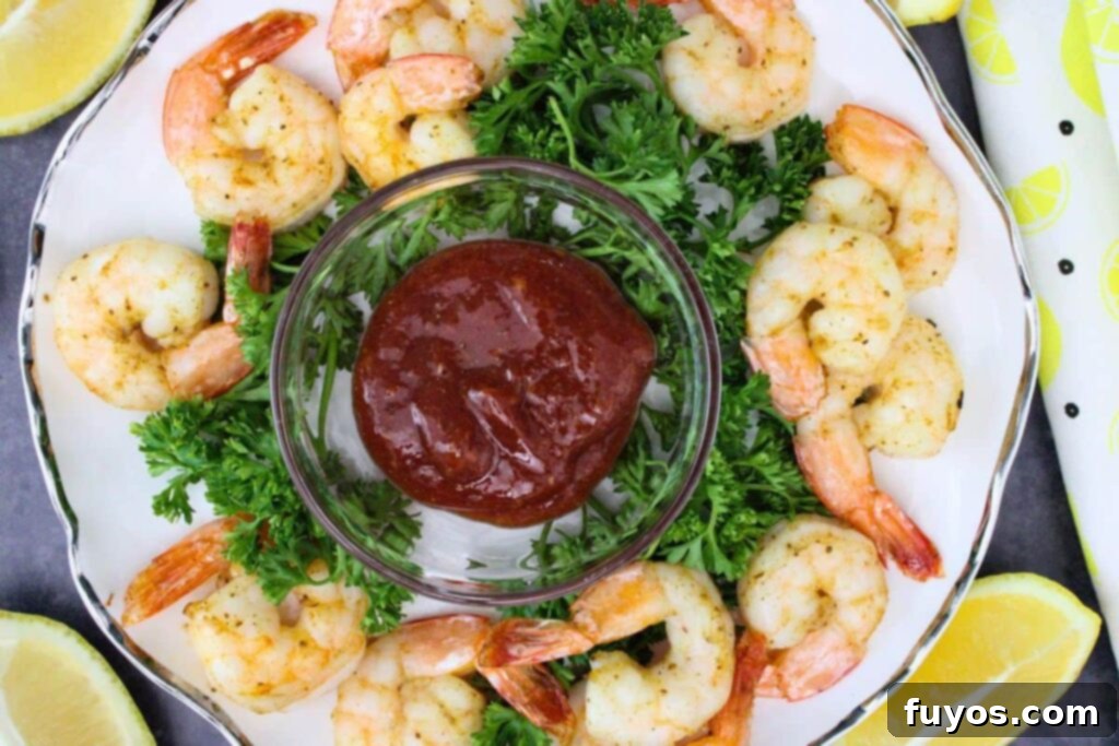Air Fryer Shrimp Cocktail Easy Elegance 8 overhead view of air fryer shrimp cocktail circling a dish of homemade cocktail sauce and fresh parsley