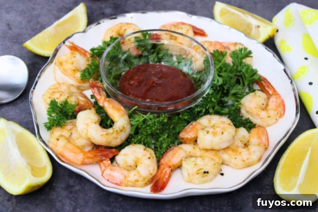 Air Fryer Shrimp Cocktail Easy Elegance 9 air fryer shrimp on a plate with homemade cocktail sauce and fresh parsley and lemon garnish
