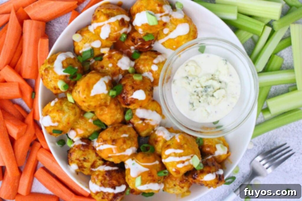Air Fryer Buffalo Chicken Meatballs So Good So Simple 9 overhead view of air fryer chicken meatballs on a plate with blue cheese dressing surrounded by carrots and celery