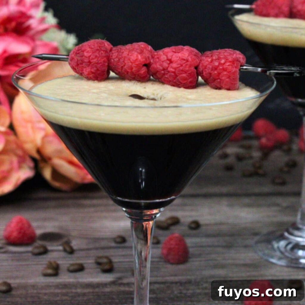 Chambord Raspberry Espresso Martini Made Easy 2 A stunning Raspberry Espresso Martini, garnished with fresh raspberries and coffee beans, perfect for a luxurious evening. The cocktail sits on a stylish surface, inviting a delightful sip.