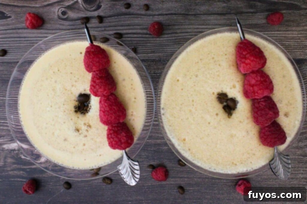 Chambord Raspberry Espresso Martini Made Easy 7 An overhead view of two finished Raspberry Espresso Martinis, beautifully garnished with fresh raspberry skewers and three coffee beans each, ready to be enjoyed.