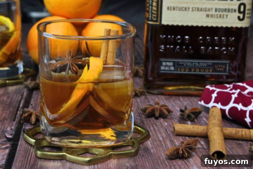 Chai Old Fashioned: The Warm Spice Bourbon 8 chai old fashioned with orange peel and cinnamon sticks next to bourbon whiskey bottle