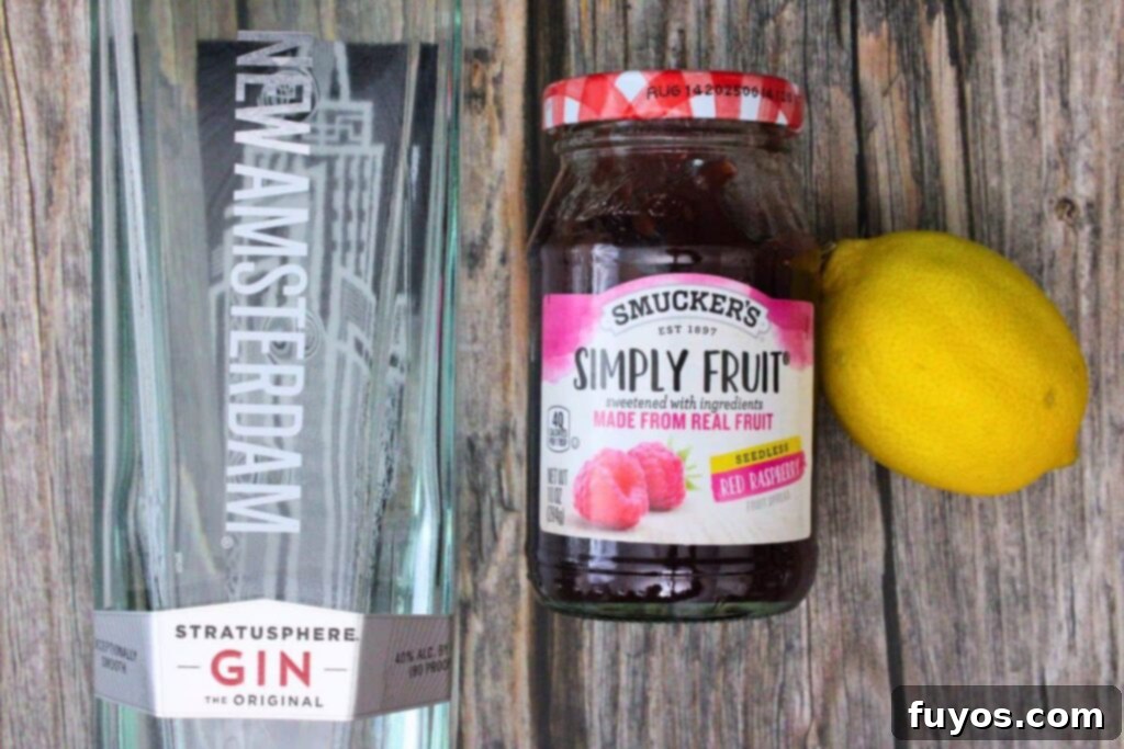 Display of the three essential ingredients for a Gin and Jam cocktail: gin, a jar of raspberry jam, and fresh lemons.