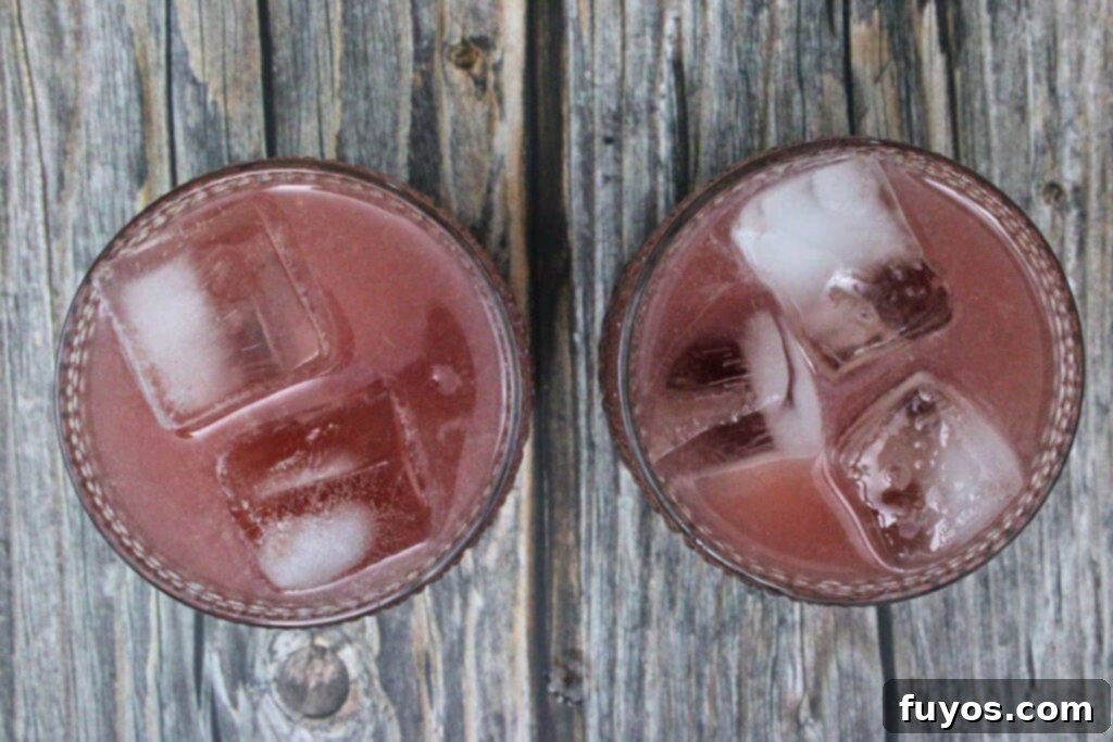 A cocktail shaker with ice being shaken to mix and chill the gin and jam cocktail ingredients.