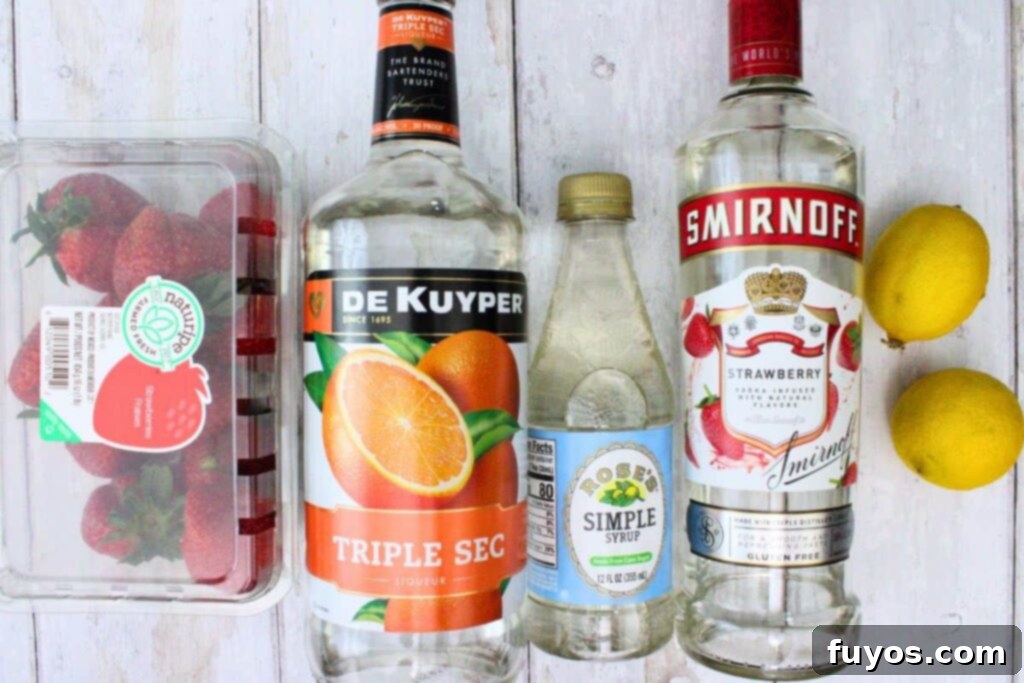 A spread of ingredients including vodka, lemons, triple sec, simple syrup, and fresh strawberries, laid out for a martini.