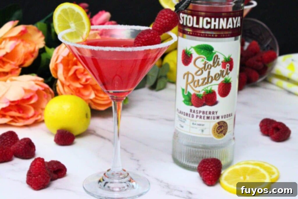 The Ultimate Homemade Raspberry Lemon Drop Cheesecake 3 raspberry lemon drop garnished with lemon and raspberries next to vodka bottle