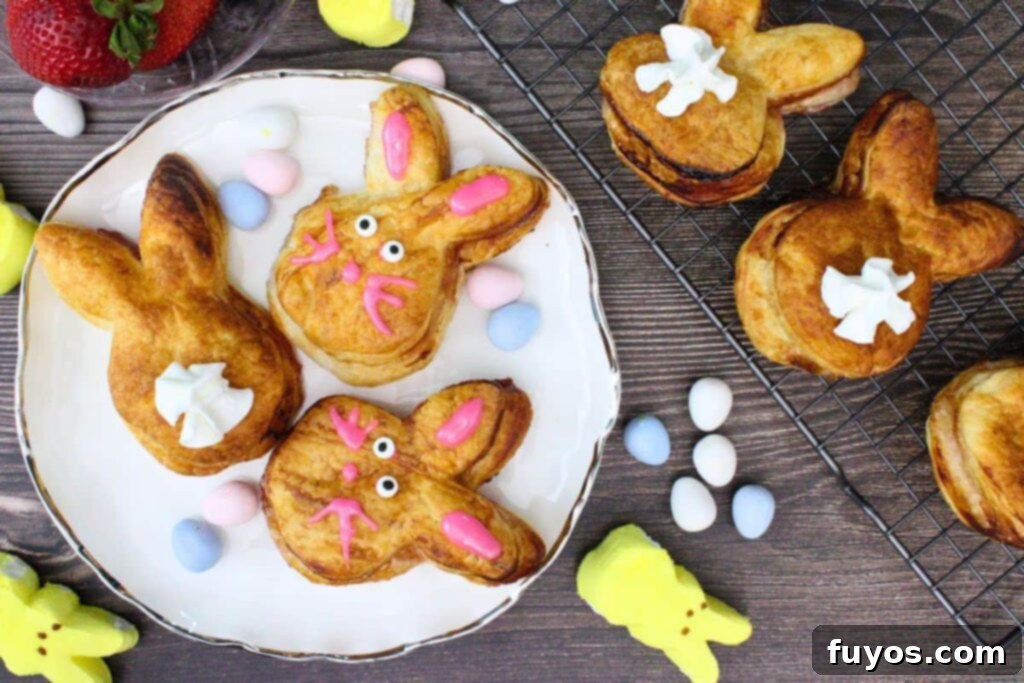 Cute Easter Air Fryer Puff Pastry Bunnies 11 overhead view of puff pastry bunnies on a plate showing their face and one face down with a whipped cream tail