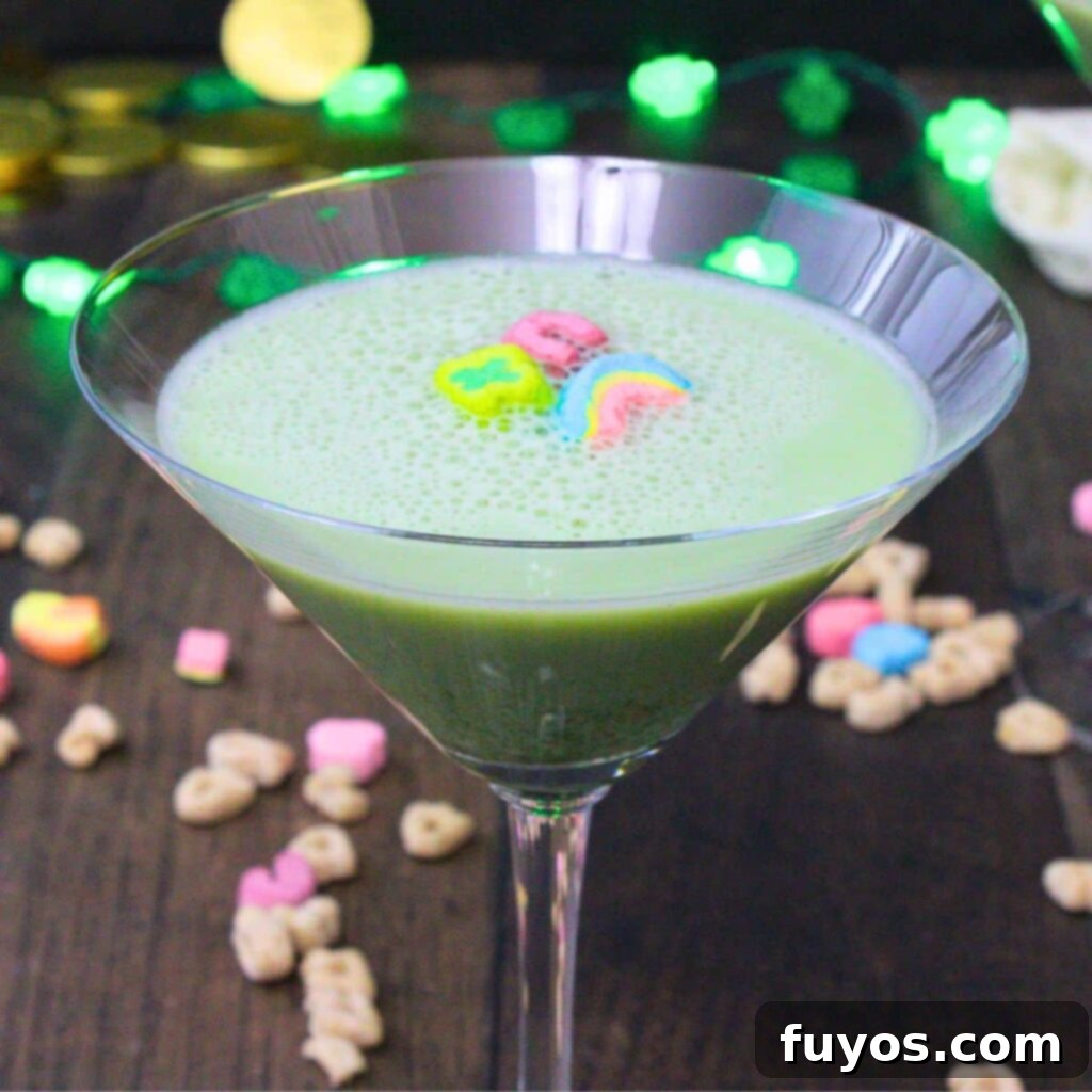 St Patricks Day Lucky Charms Baileys Martini 2 A vibrant green Lucky Charms martini cocktail, garnished with fluffy marshmallows and cereal, set against a festive backdrop.