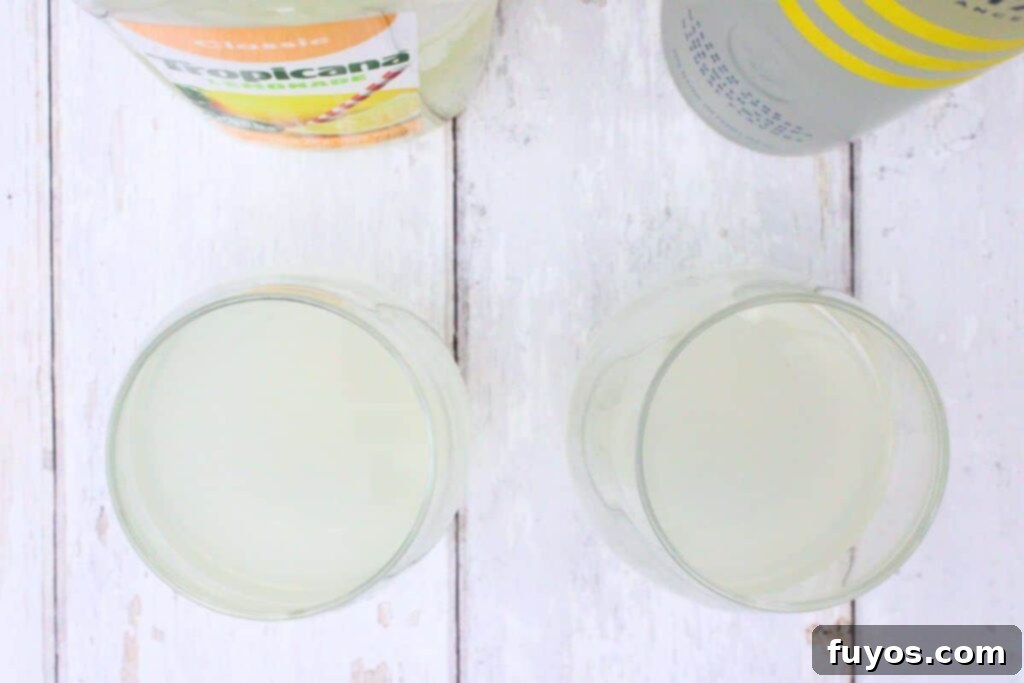 Zesty Sparkling Vodka Lemonade 5 Step-by-step image showing vodka and lemonade being poured into a stemless wine glass.