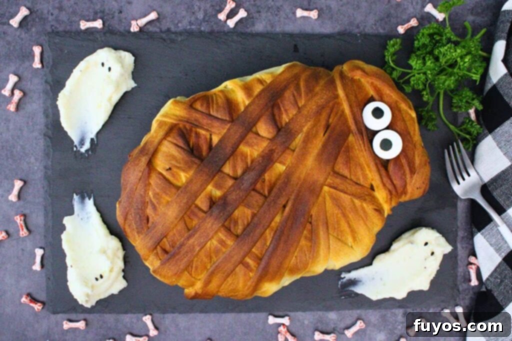 Spooky Halloween Air Fryer Mummy Meatloaf 11 overhead view of mummy meatloaf on a black slate with ghost mashed potatoes and parsley