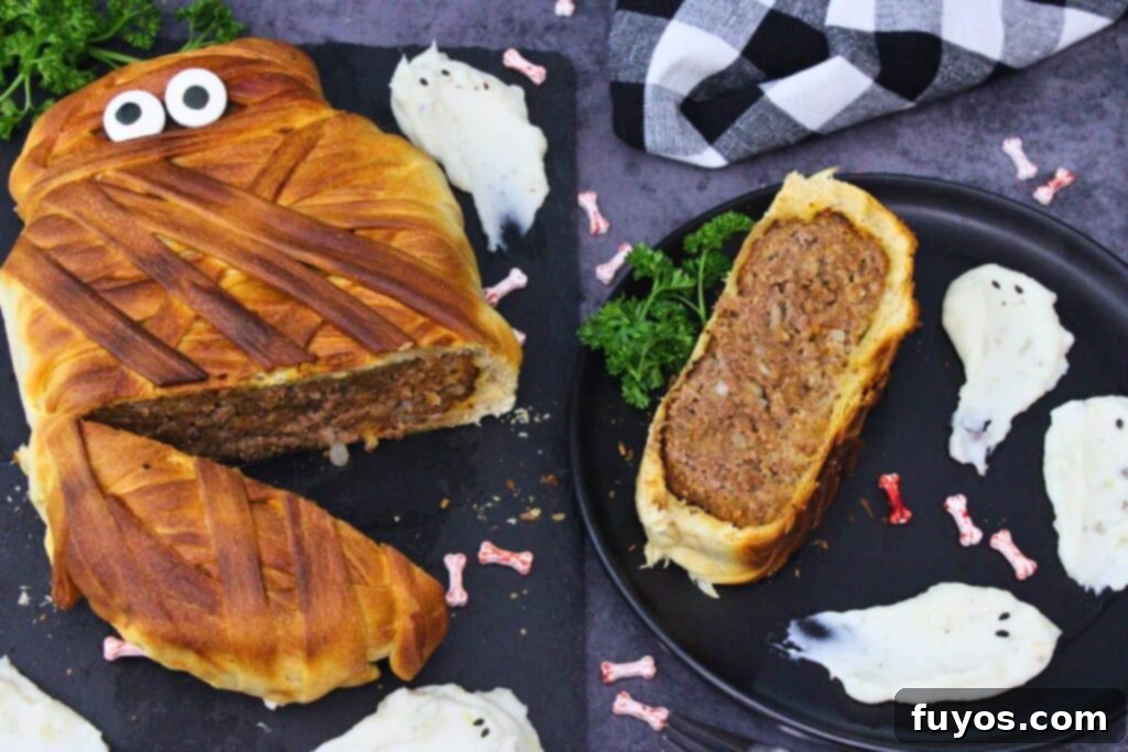 Spooky Halloween Air Fryer Mummy Meatloaf 12 air fryer mummy meatloaf cut open with a slice off to the side on a plate with ghost mashed potatoes
