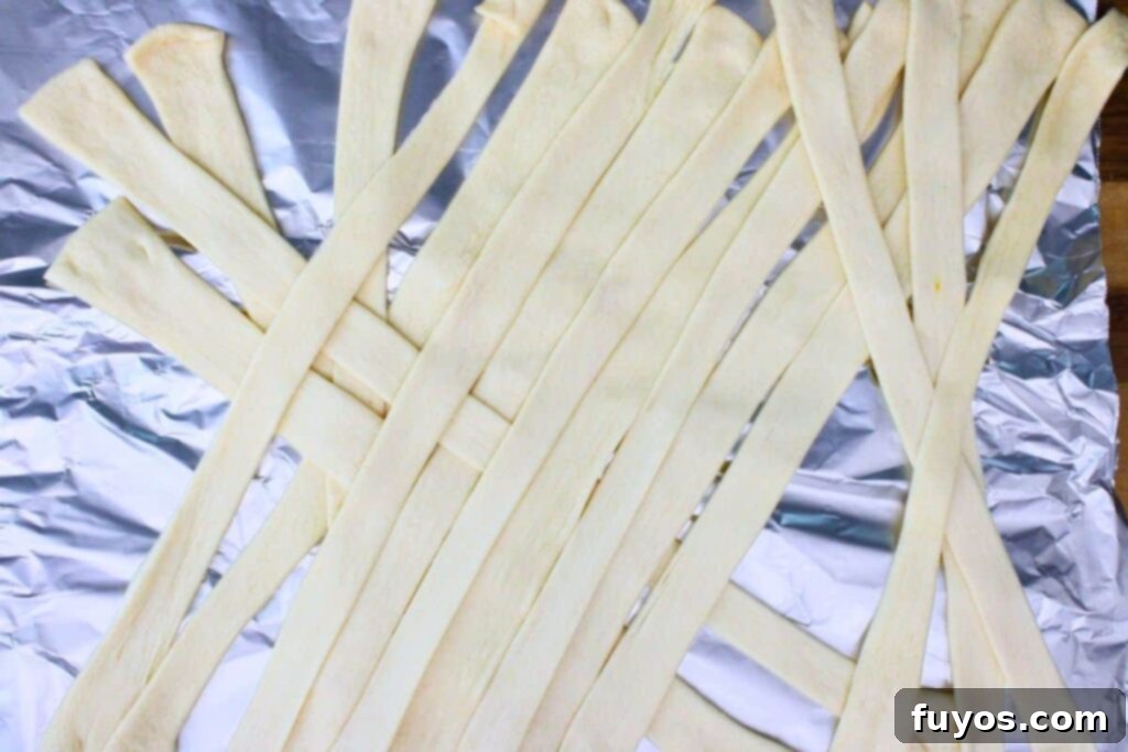 Spooky Halloween Air Fryer Mummy Meatloaf 9 lay crescent dough in crossing strips to mimic mummy pattern