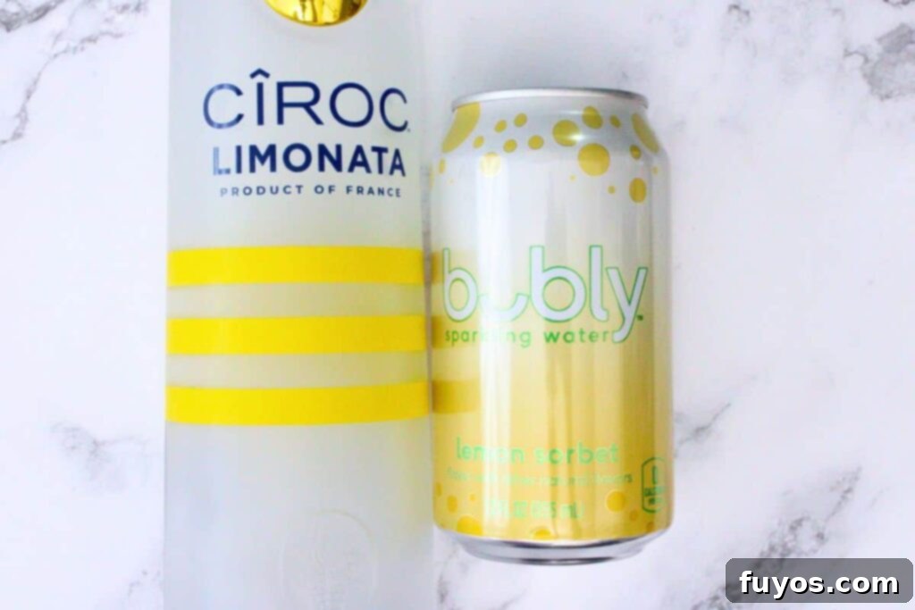 ingredients laid out to make a sparkling lemonade cocktail: Ciroc Limonata vodka, lemon sparkling water, lemons, ice, rosemary
