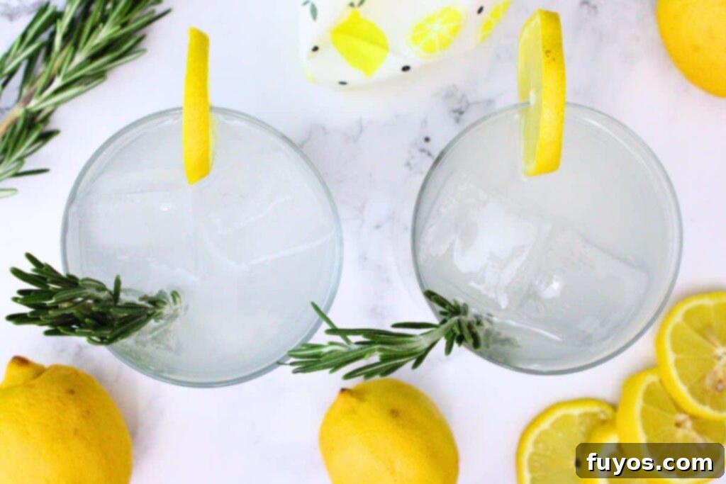 overhead view of two sparkling lemonade cocktails garnished with lemon and rosemary