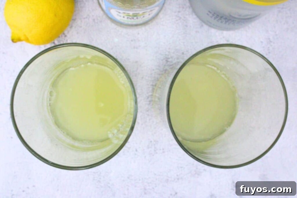 Lemon Vodka Collins: Summer's Zesty Escape 5 Pouring vodka, simple syrup, and lemon juice into a highball glass