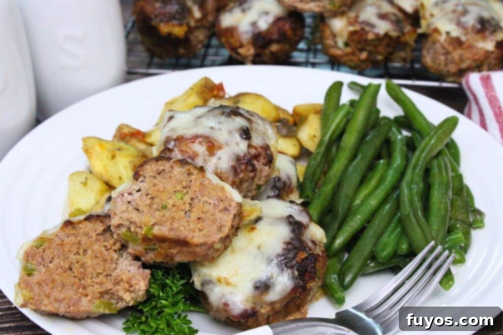 plate of philly cheesesteak meatloaf muffins with one cut in half to show the insides