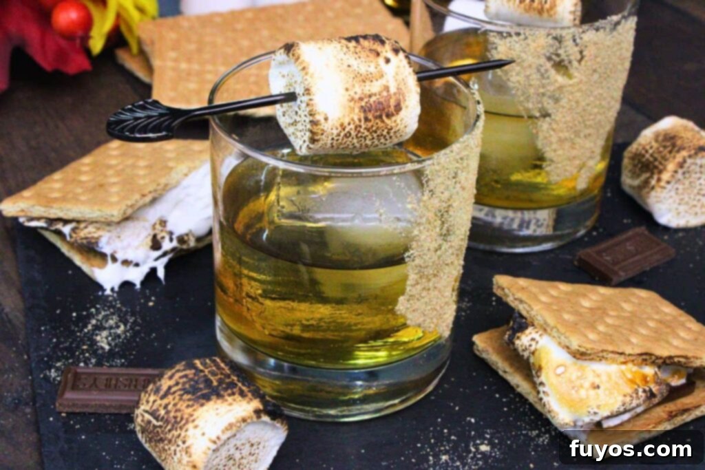 S'mores Old Fashioned: Campfire Nostalgia in a Glass 9 s'mores old fashioned cocktail with toasted marshmallow skewer surrounded by fresh smores