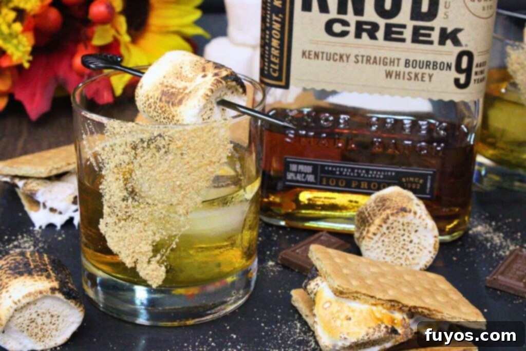 S'mores Old Fashioned: Campfire Nostalgia in a Glass 3 s'mores old fashioned next to bourbon bottle and smores