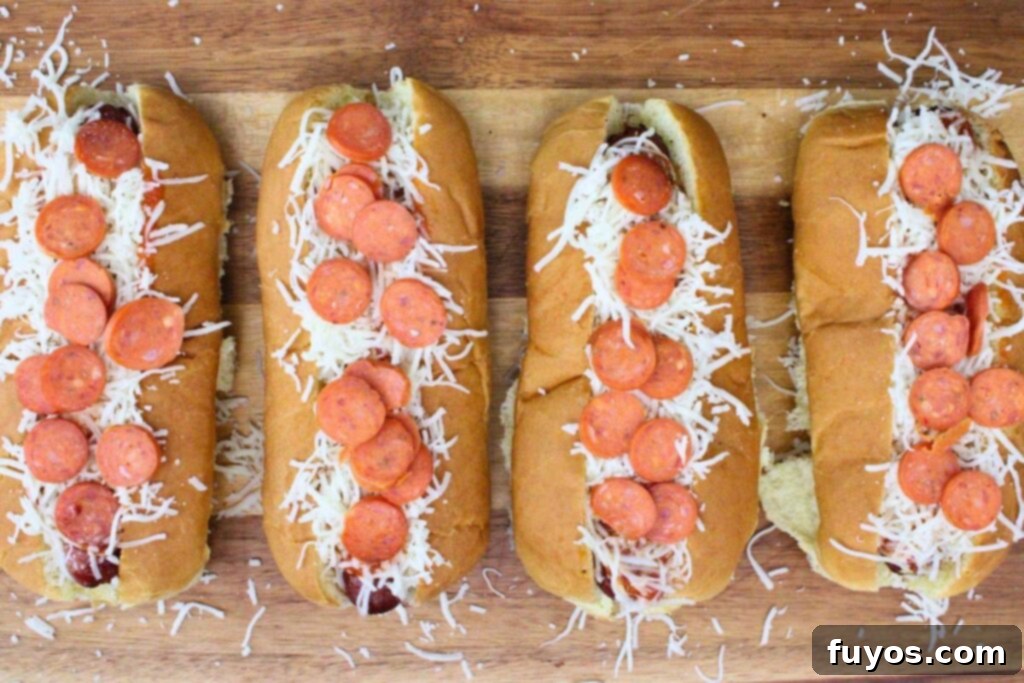 Pizza Hot Dogs: Your Go-To 30-Minute Flavor Fusion 6 top cooked hot dogs with pizza sauce, italian seasoning, mozzarella cheese, and mini pepperoni