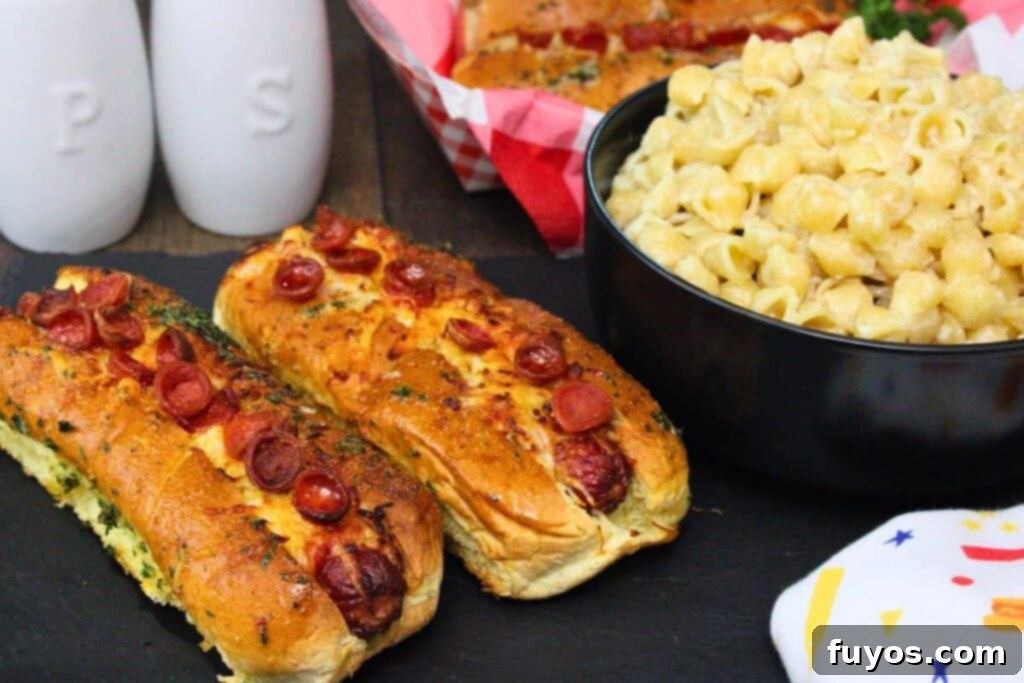 Pizza Hot Dogs: Your Go-To 30-Minute Flavor Fusion 10 two pizza hot dogs topped with pepperoni and garlic butter next to a bowl of mac and cheese on a black slate tray