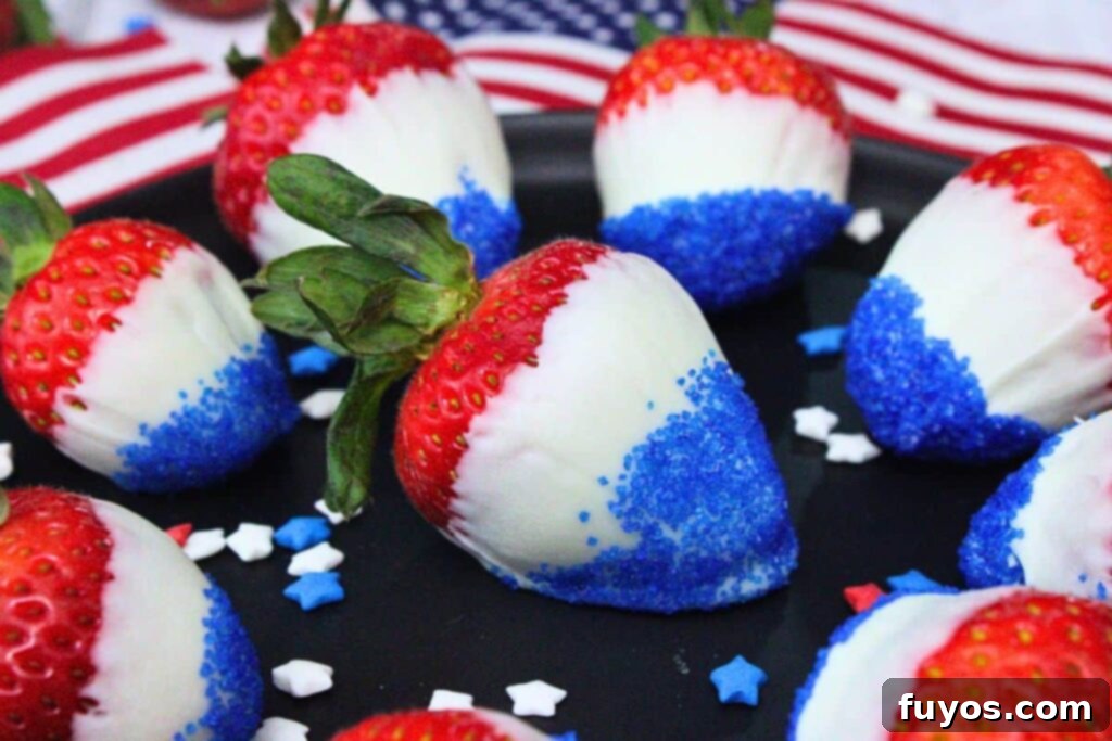 closeup view of a large red white and blue strawberry on a black plate with more surrounding it