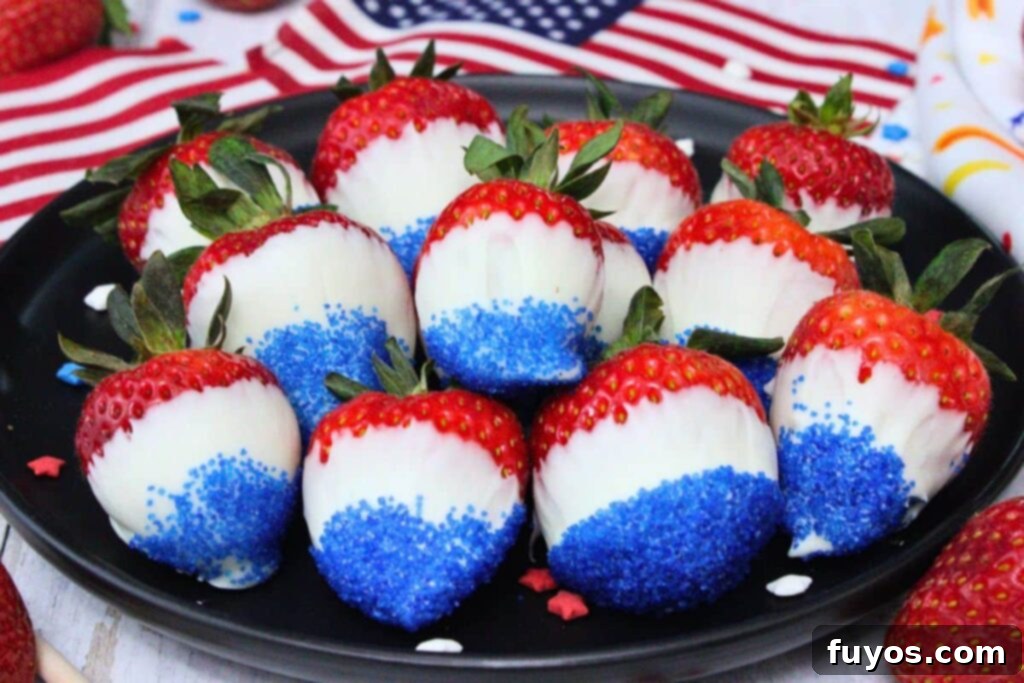 red white and blue strawberries piled on a black plate in front of american flags