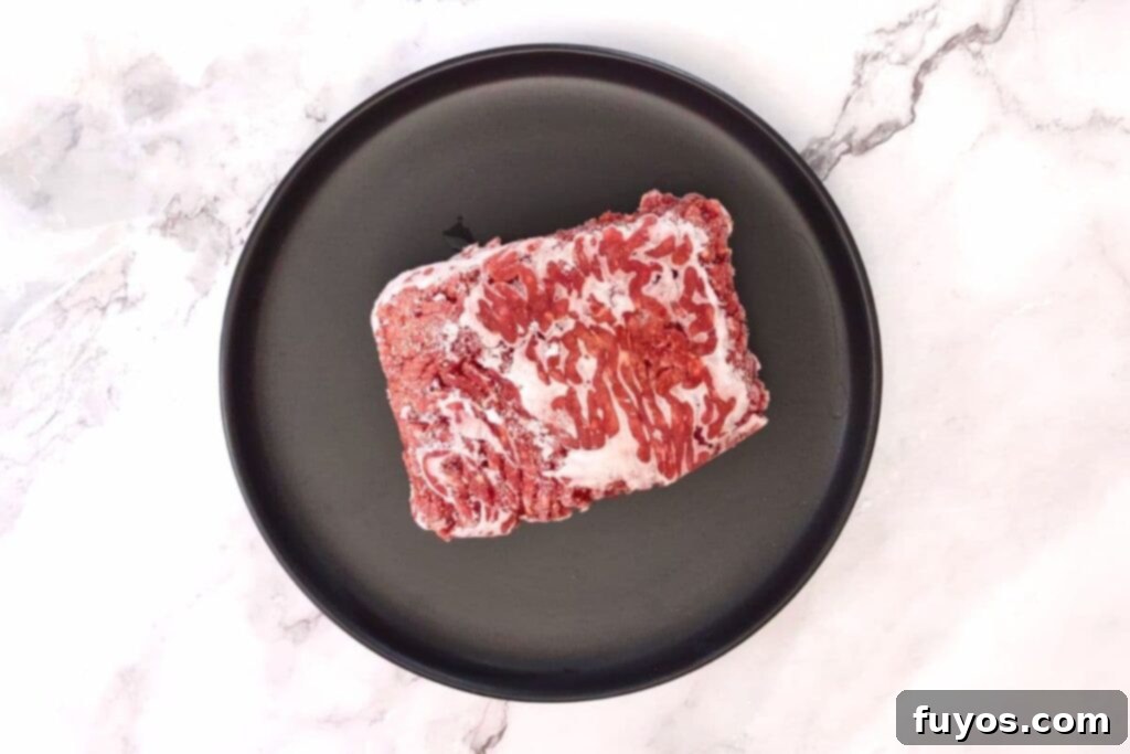 Mastering Microwave Defrosting for Ground Beef 5 place frozen beef on a microwave safe plate with a lip