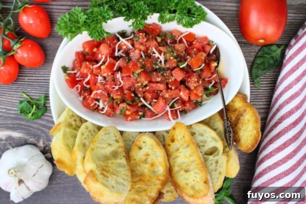 Overhead view of a bowl of fresh tomato bruschetta topping with air fryer toasted baguette slices arranged around it