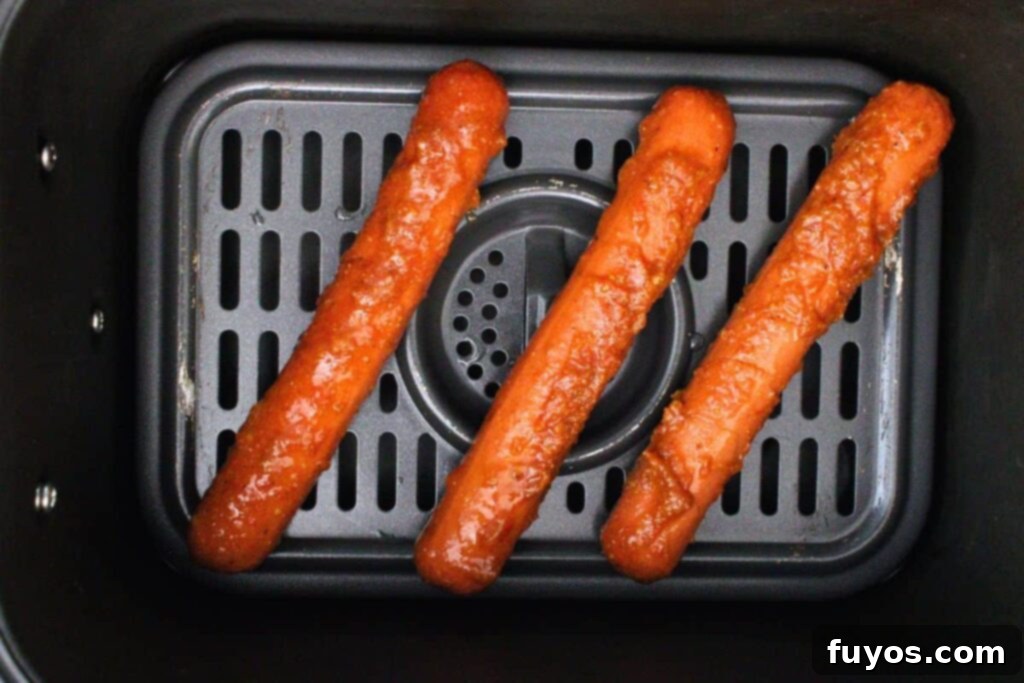 Flavor-Packed Air Fryer Franks 7 place marinated hot dogs in air fryer basket