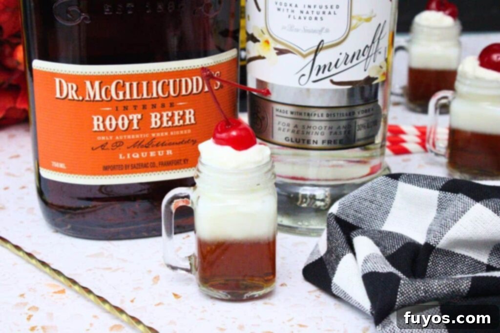 Grown-Up Root Beer Float Shots: A Sip of Summer Nostalgia 3 root beer float shot topped with whipped cream and cherry in front of schnapps and vodka bottles