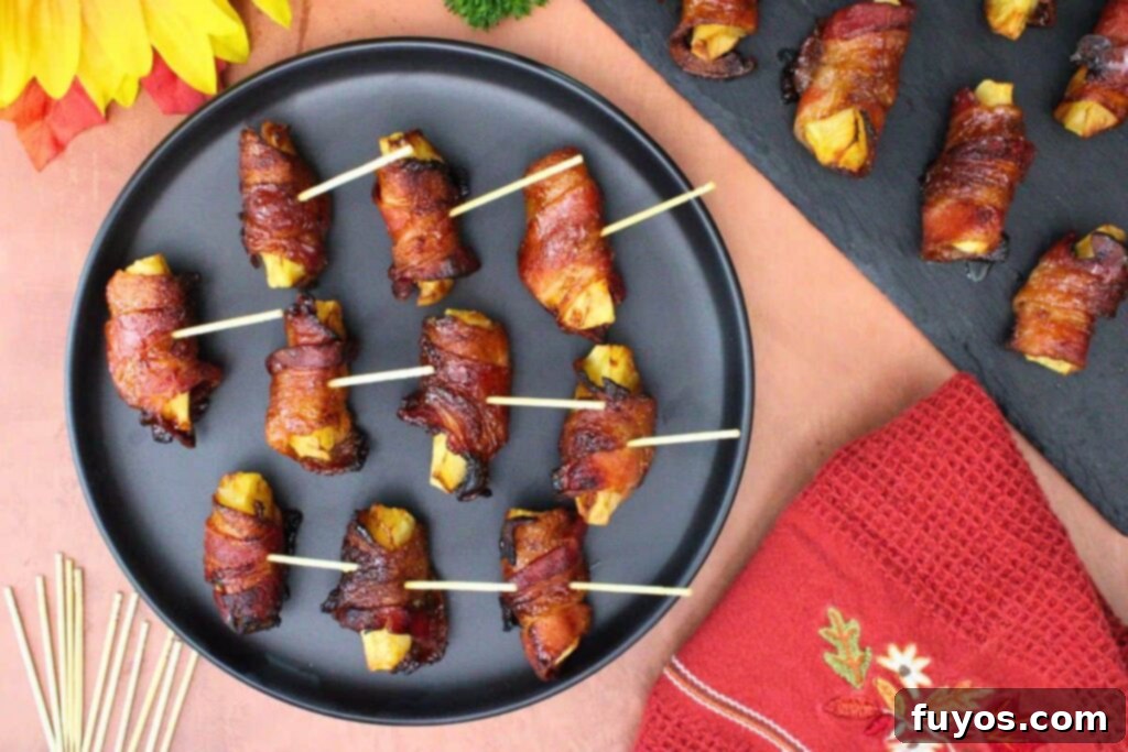 Sweet and Savory Air Fryer Bacon Apple Bites 8 overhead view of bacon wrapped apples with toothpicks on a black plate