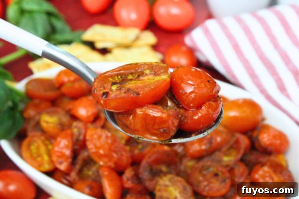 holding up a spoon of air fryer cherry tomatoes with plenty more in the background