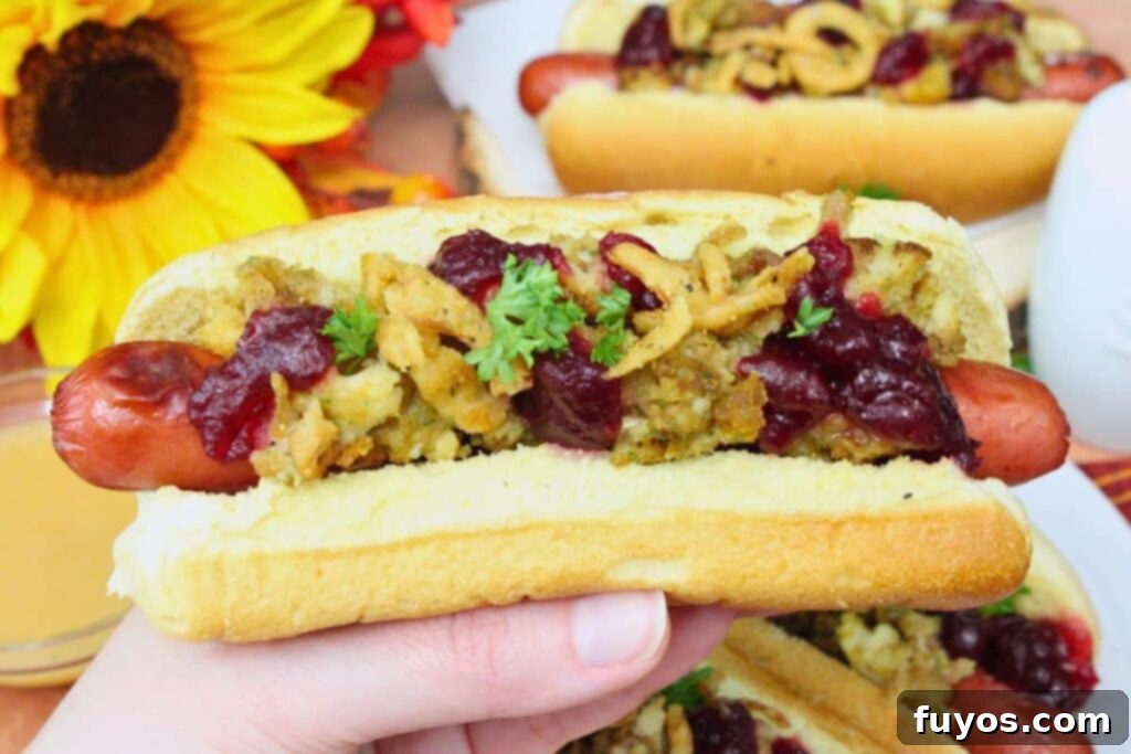 Air Fryer Thanksgiving Hot Dogs: Effortless Holiday Eats 3 holding up an air fryer thanksgiving hot dog showing off the stuffing, cranberry sauce, and crispy fried onions