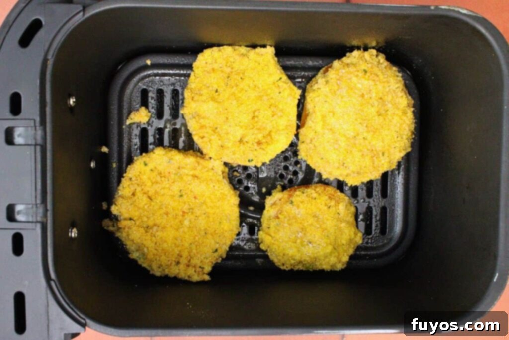 Golden Air Fryer Green Tomatoes with Irresistible Hot Honey Ranch 9 place breaded green tomatoes in air fryer basket