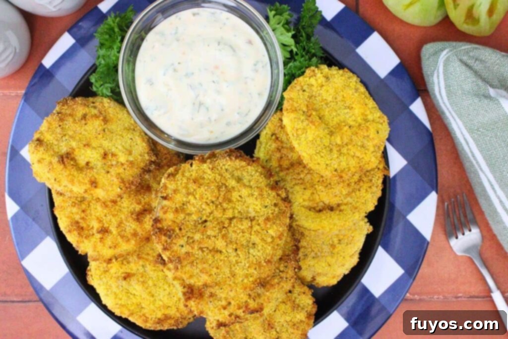 Golden Air Fryer Green Tomatoes with Irresistible Hot Honey Ranch 10 overhead view of air fryer fried green tomatoes on a blue plate with hot honey ranch dipping sauce