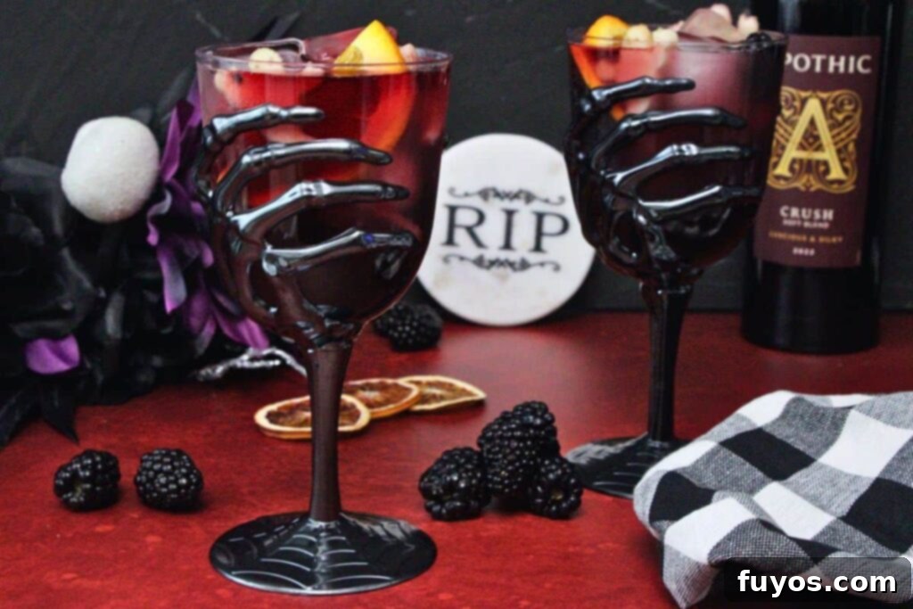 Midnight Ritual Sangria A Bewitching Adult Brew 3 two skeleton hand goblets filled with halloween sangria showcasing ghost shaped apple slices and orange