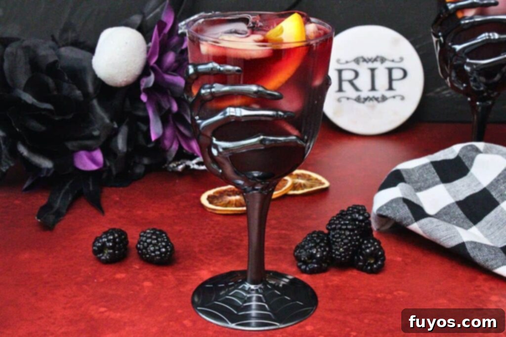 Midnight Ritual Sangria A Bewitching Adult Brew 9 skeleton goblet filled with dark red halloween sangria showing off fruit slices