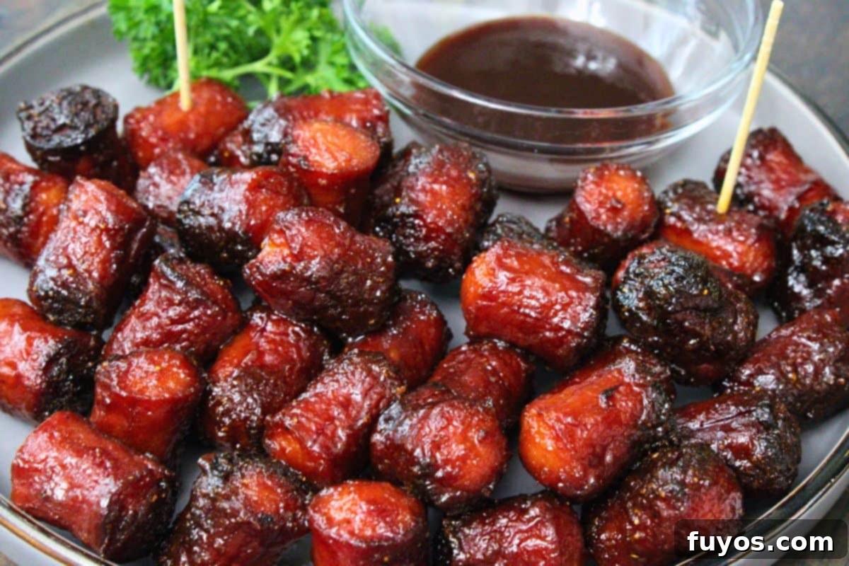 27 Irresistible Air Fryer Hot Dog Creations 16 closeup view of hot dog burnt ends on a plate with bbq sauce for dipping
