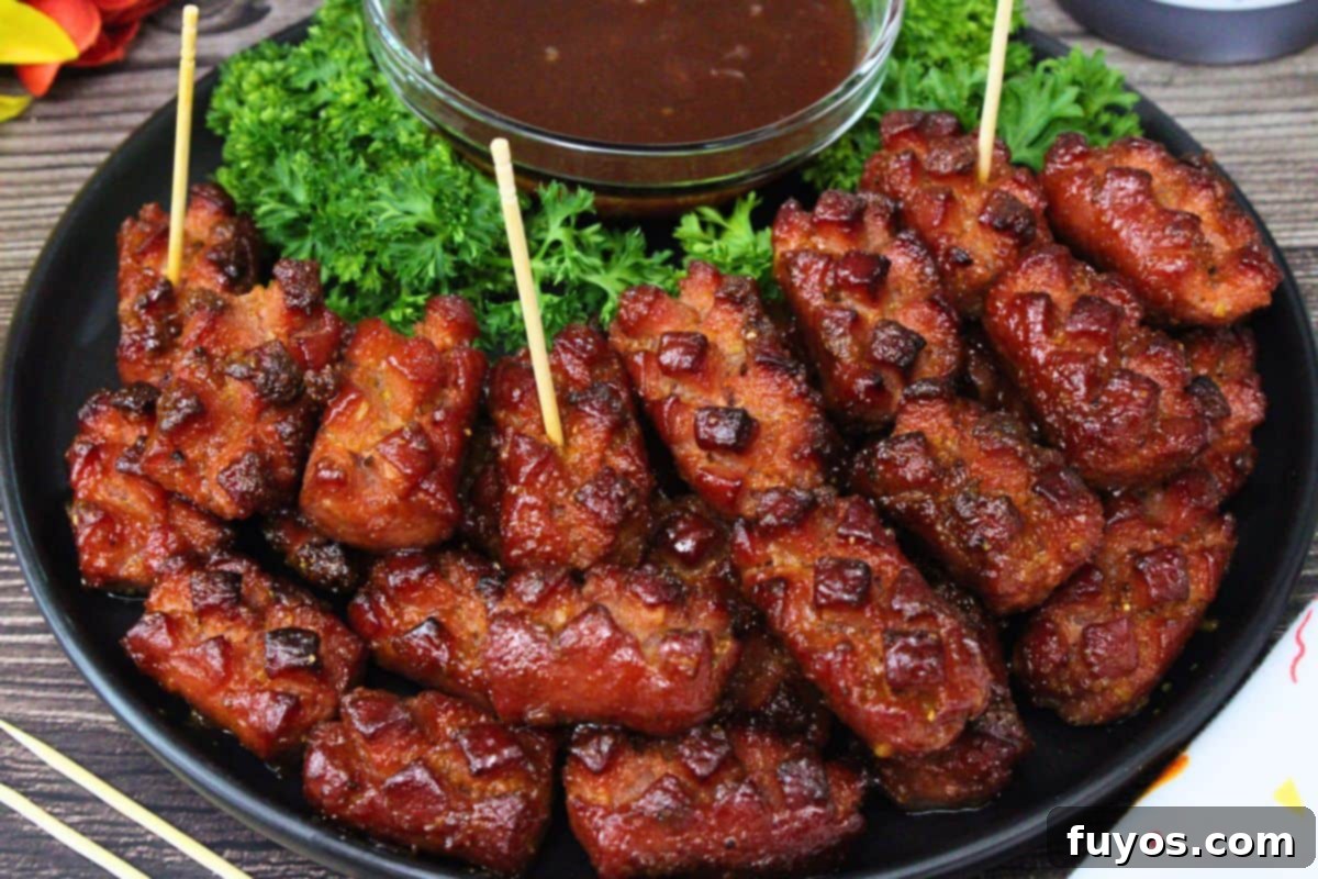 27 Irresistible Air Fryer Hot Dog Creations 17 plate of air fryer hot dog pinecones on a black plate with a small dish of bbq sauce