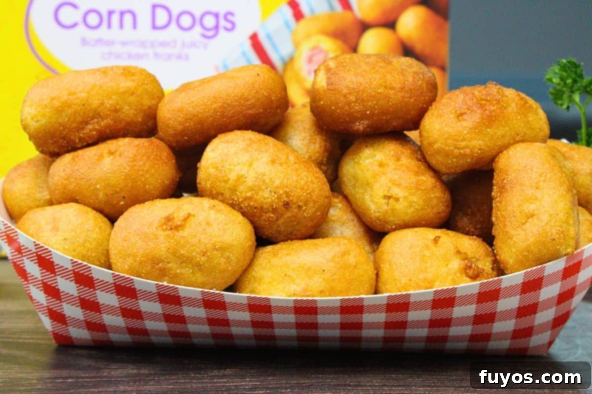 27 Irresistible Air Fryer Hot Dog Creations 22 checkered basket filled with golden brown air fryer mini corn dogs in front of the box