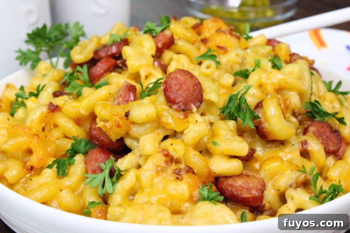 27 Irresistible Air Fryer Hot Dog Creations 24 closeup view of hot dog mac and cheese mounded on a plate garnished with parsley