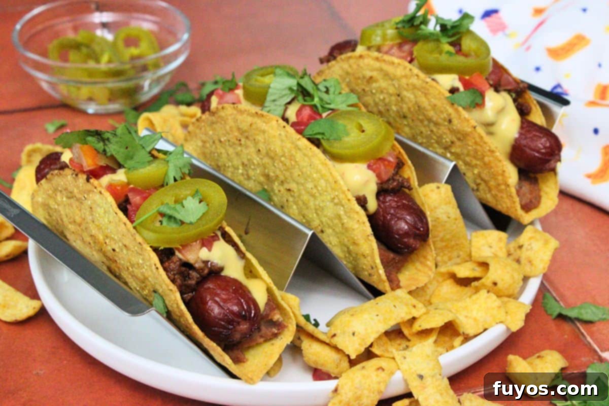 27 Irresistible Air Fryer Hot Dog Creations 6 three taco hot dogs in hard shells with queso and jalapenos surrounded by corn chips