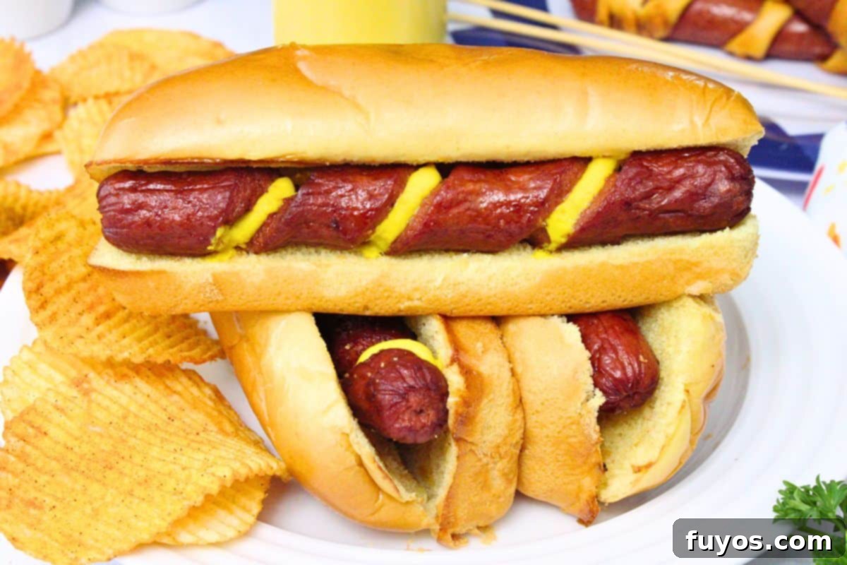 27 Irresistible Air Fryer Hot Dog Creations 9 three spiral hot dogs stacked on a white plate with the top on showing mustard in the spiral cuts
