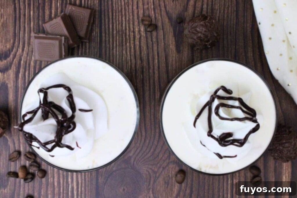 Decadent Chocolate Crown Royal White Russian 7 overhead view of two crown royal chocolate white russians with whipped cream and chocolate on a wooden table